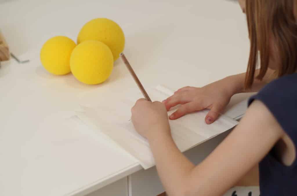 Kind schreibt am Tisch – ergotherapeutisches Training der Schreibmotorik